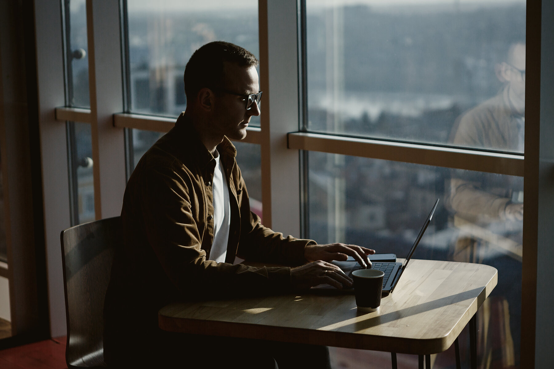 A seller reviewing an order at a desk beside a window